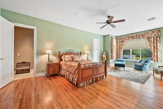 bedroom with light hardwood / wood-style floors and ceiling fan