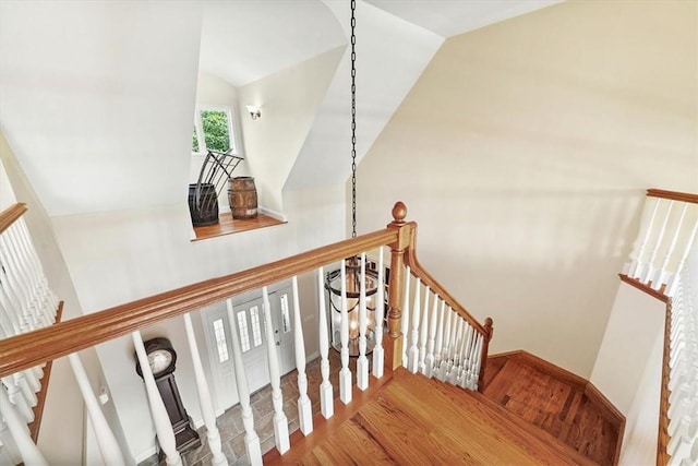 stairs featuring hardwood / wood-style floors and lofted ceiling