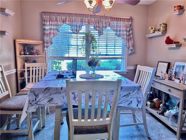 tiled dining room featuring an inviting chandelier