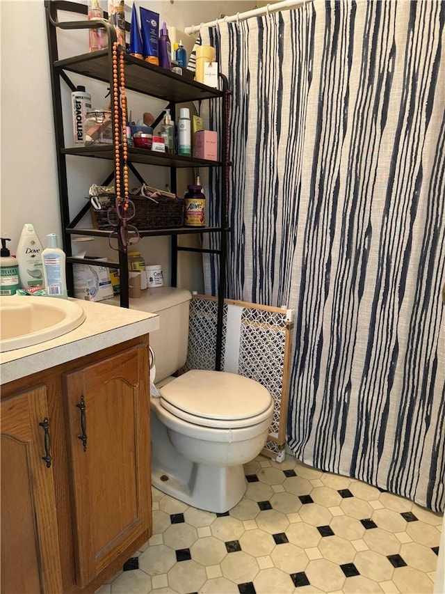 bathroom featuring vanity, toilet, and walk in shower