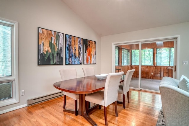 dining room featuring lofted ceiling, light wood-type flooring, and baseboard heating