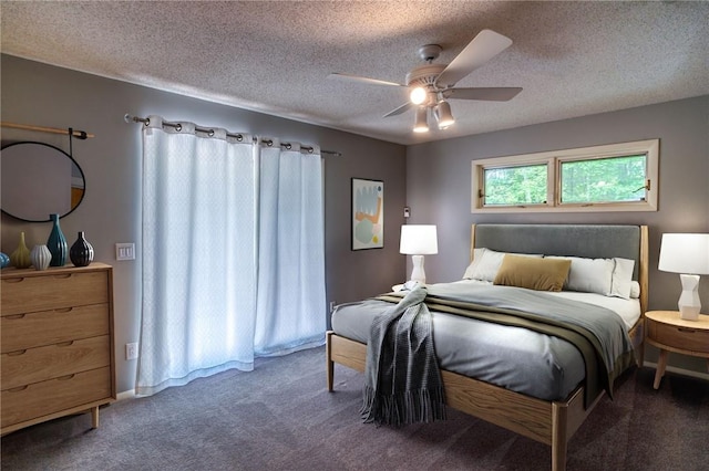 bedroom with ceiling fan, carpet floors, and a textured ceiling