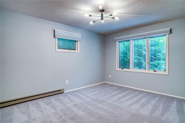 carpeted spare room with an inviting chandelier, a textured ceiling, and a baseboard heating unit