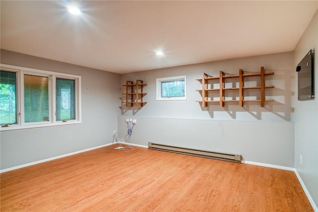 spare room featuring wood-type flooring and baseboard heating