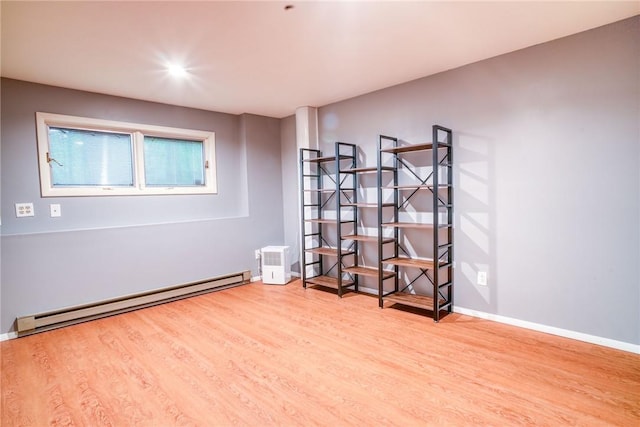 empty room featuring light hardwood / wood-style flooring and a baseboard heating unit