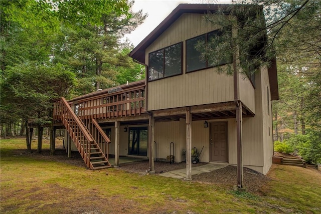 back of house with a lawn and a deck