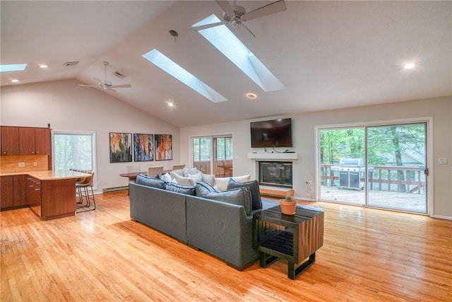 living room featuring a wealth of natural light, ceiling fan, and light hardwood / wood-style flooring