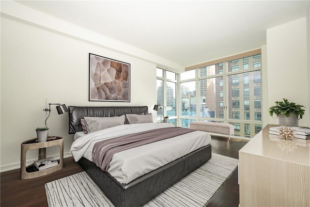 bedroom featuring dark hardwood / wood-style floors and a wall of windows