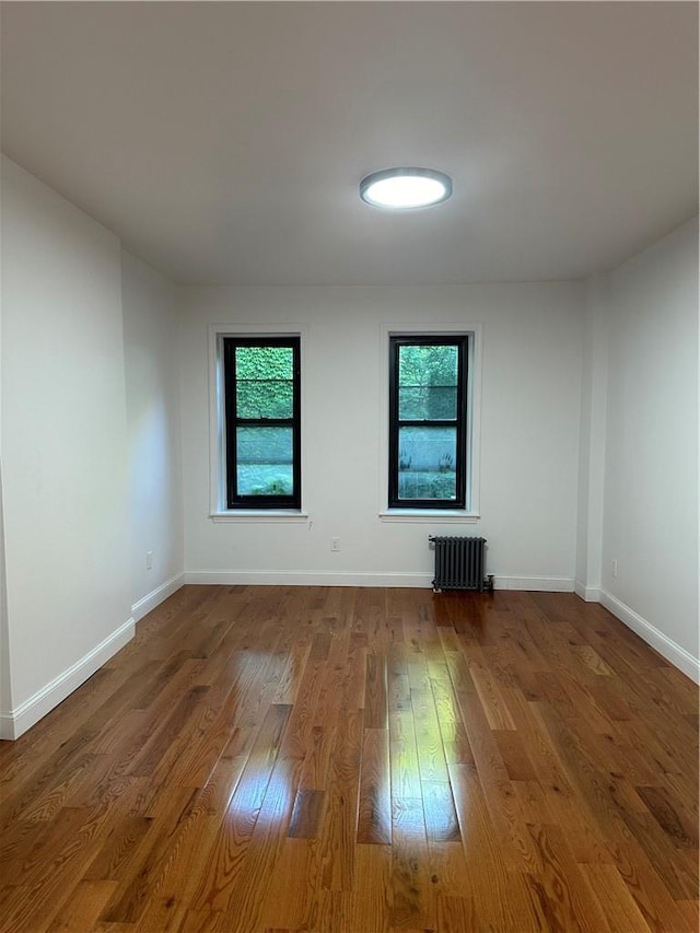 spare room with wood-type flooring and radiator heating unit