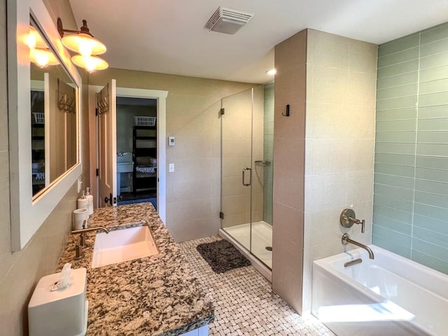 bathroom with tile patterned flooring, vanity, separate shower and tub, and tile walls