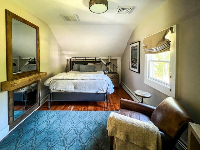 bedroom featuring dark hardwood / wood-style flooring, a baseboard radiator, and vaulted ceiling