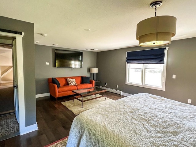 bedroom featuring dark hardwood / wood-style flooring and a baseboard heating unit