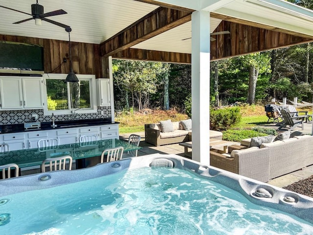 view of patio / terrace featuring a hot tub, an outdoor hangout area, area for grilling, and ceiling fan