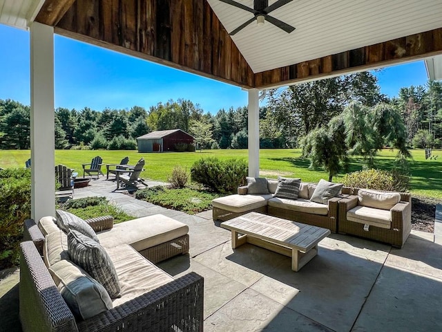 view of patio / terrace featuring ceiling fan and an outdoor living space with a fire pit