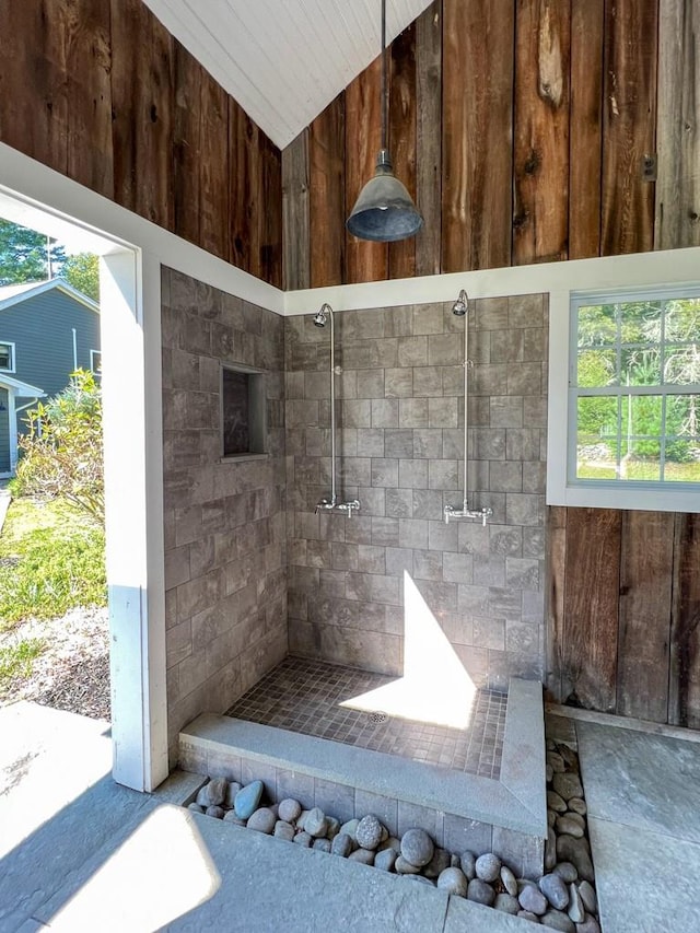 bathroom with a wealth of natural light and wooden walls