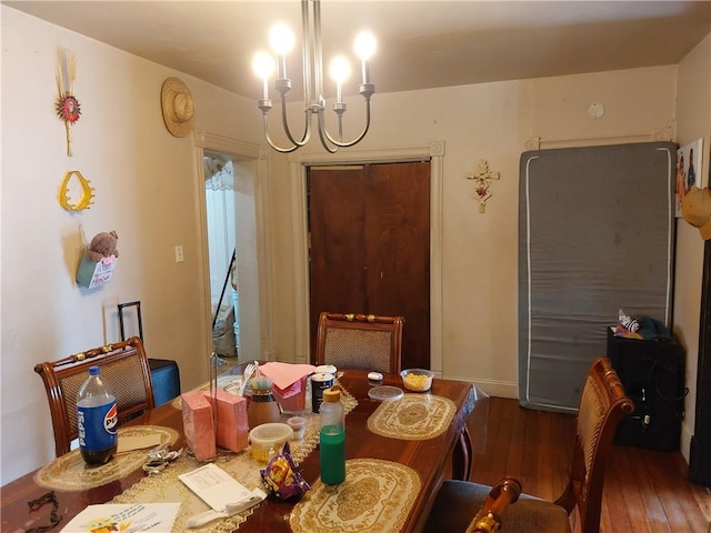 dining area featuring dark hardwood / wood-style floors and an inviting chandelier