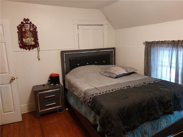 bedroom featuring dark wood-type flooring and vaulted ceiling