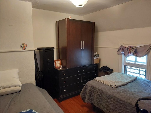 bedroom featuring wood-type flooring and vaulted ceiling