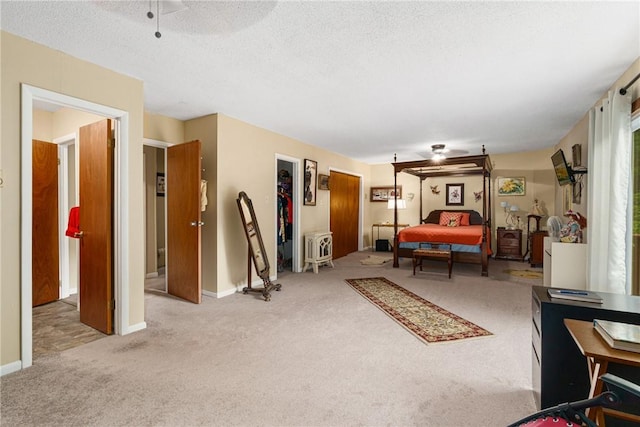 bedroom featuring ceiling fan, light colored carpet, and a textured ceiling