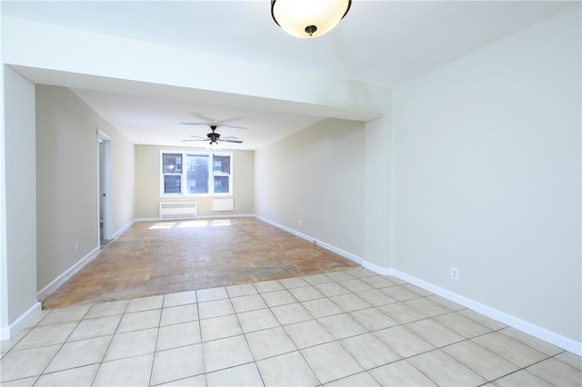 empty room with radiator, ceiling fan, and light hardwood / wood-style flooring