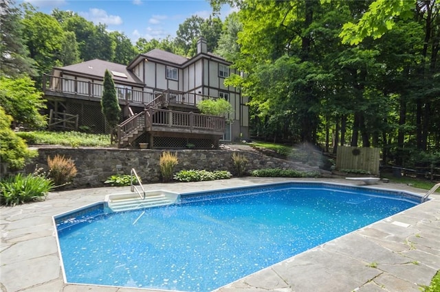 view of swimming pool featuring a diving board and a wooden deck