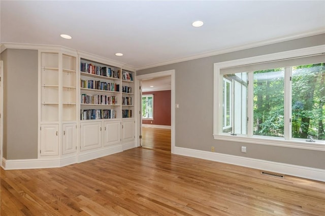 spare room with light hardwood / wood-style flooring and ornamental molding