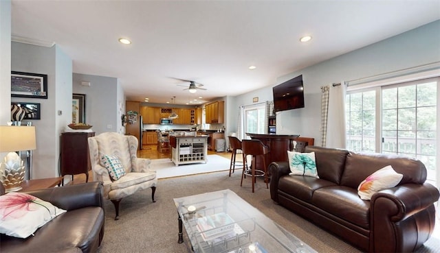 carpeted living room with ceiling fan and plenty of natural light