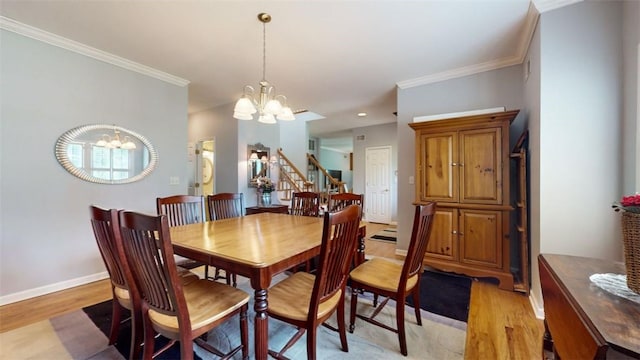 dining area with crown molding, light hardwood / wood-style flooring, and a chandelier