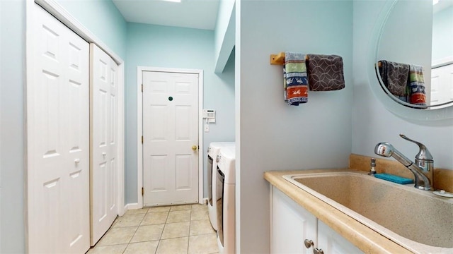 clothes washing area with light tile patterned floors and sink