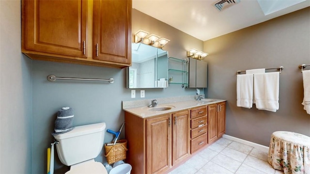 bathroom with toilet, vanity, and tile patterned floors