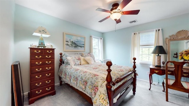 bedroom featuring ceiling fan, light colored carpet, and multiple windows