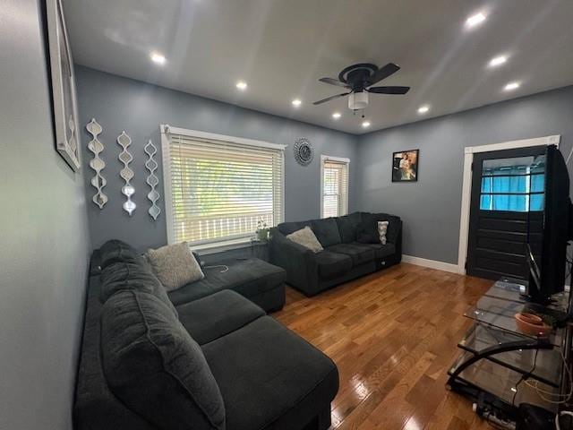 living room featuring wood-type flooring and ceiling fan