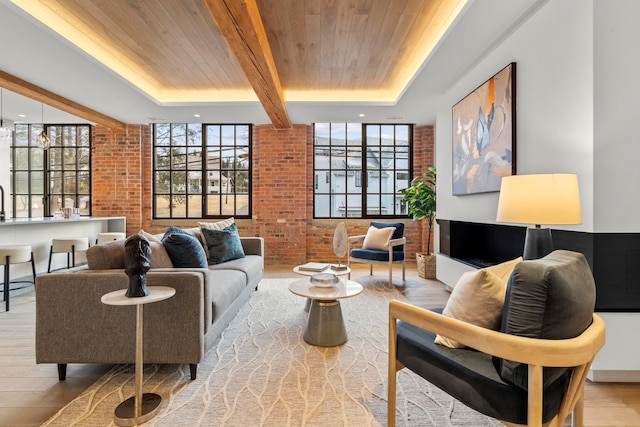 living room with wood ceiling, brick wall, and light hardwood / wood-style flooring