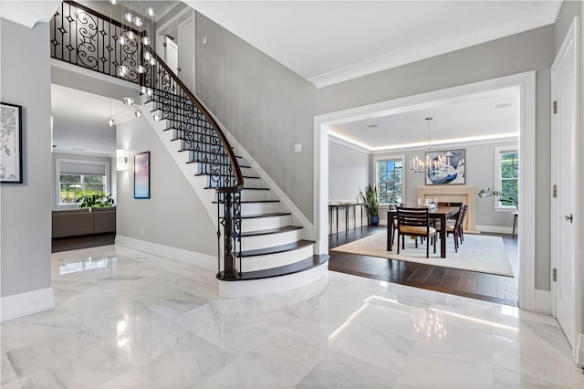 staircase featuring hardwood / wood-style floors, a notable chandelier, a healthy amount of sunlight, and crown molding