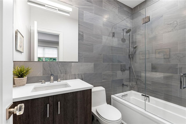 full bathroom featuring tasteful backsplash, enclosed tub / shower combo, toilet, vanity, and tile walls