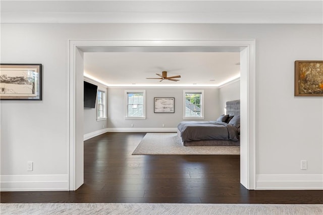 bedroom with dark hardwood / wood-style floors, ceiling fan, and crown molding