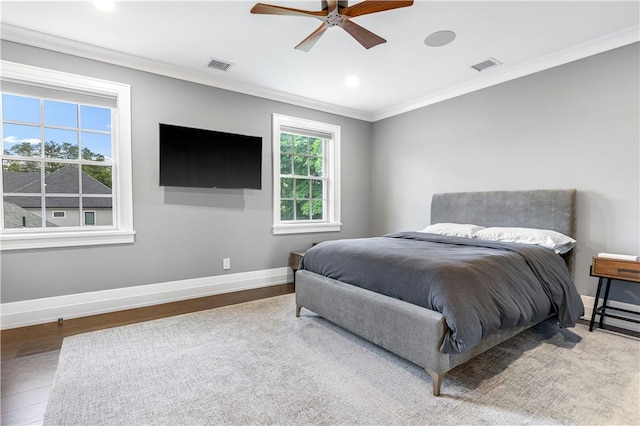 bedroom featuring ceiling fan, wood-type flooring, and crown molding