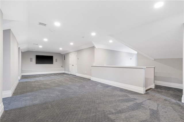 interior space with lofted ceiling and dark colored carpet