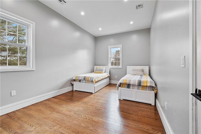 bedroom featuring light hardwood / wood-style floors and multiple windows