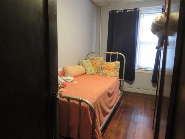 bedroom featuring dark hardwood / wood-style flooring and multiple windows