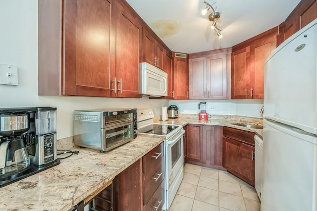 kitchen featuring light stone counters, white appliances, and light tile patterned floors