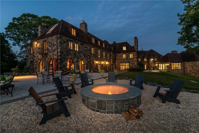 patio terrace at dusk featuring a fire pit