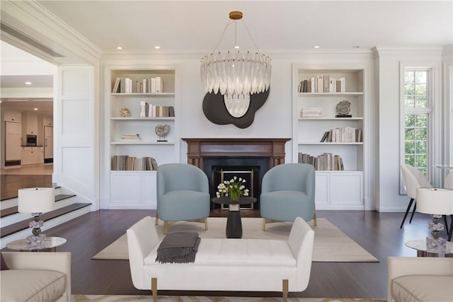 living room with built in features, a chandelier, dark hardwood / wood-style floors, and ornamental molding