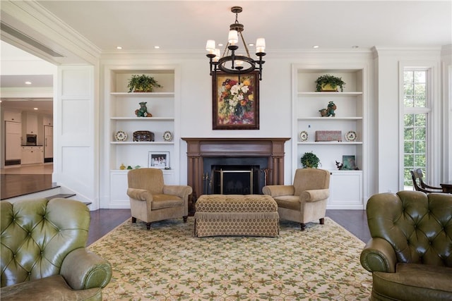 11 Carriage Trl, Tarrytown, NY 10591 - living area with built in features, a chandelier, wood finished floors, a fireplace, and crown molding