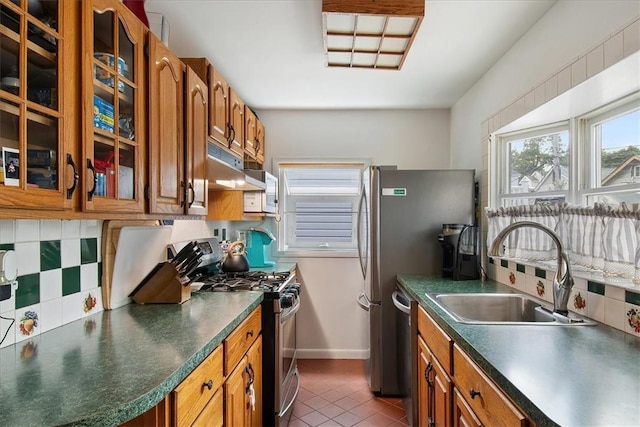 kitchen featuring backsplash, stainless steel appliances, dark tile patterned floors, and sink