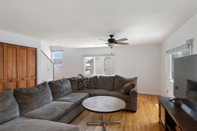 living room with ceiling fan, light hardwood / wood-style floors, and a wall mounted air conditioner