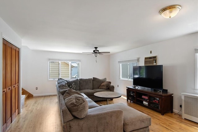 living room with a wealth of natural light, light hardwood / wood-style flooring, radiator, and ceiling fan