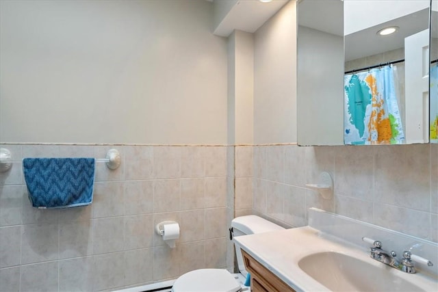 bathroom with vanity, toilet, tile walls, and curtained shower