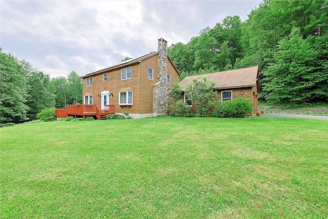 rear view of property with a yard and a wooden deck