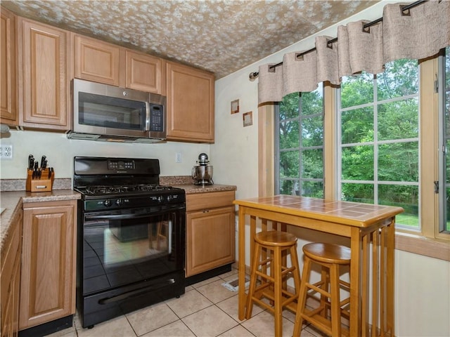 kitchen featuring black range with gas cooktop and light tile patterned floors